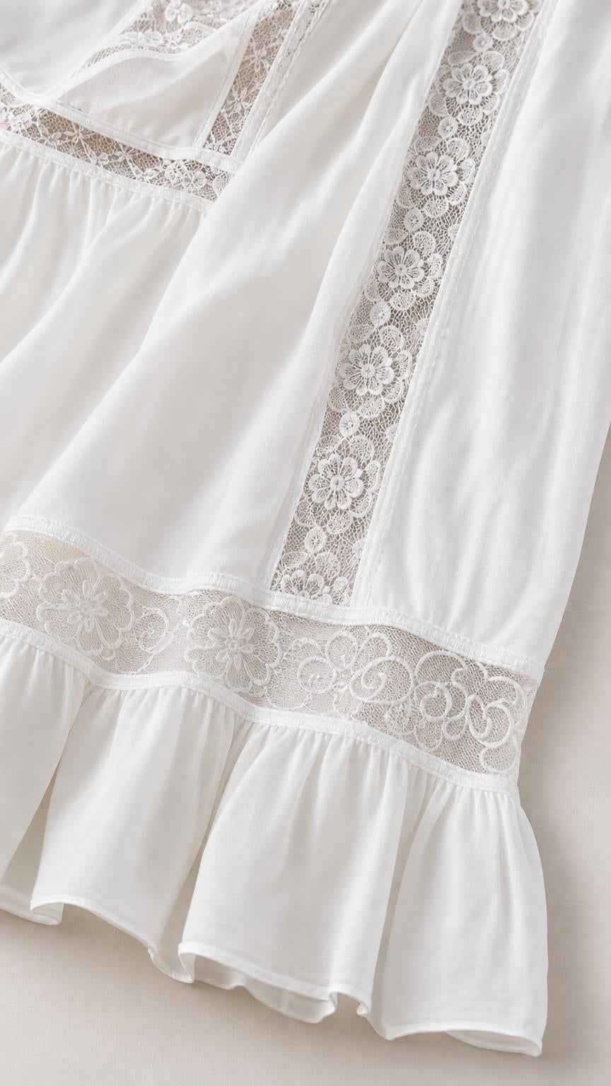 Close-up detail of lace trim and ruffle hem on white dress