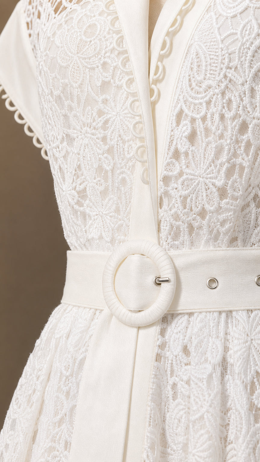Close-up of white lace texture and belt detail