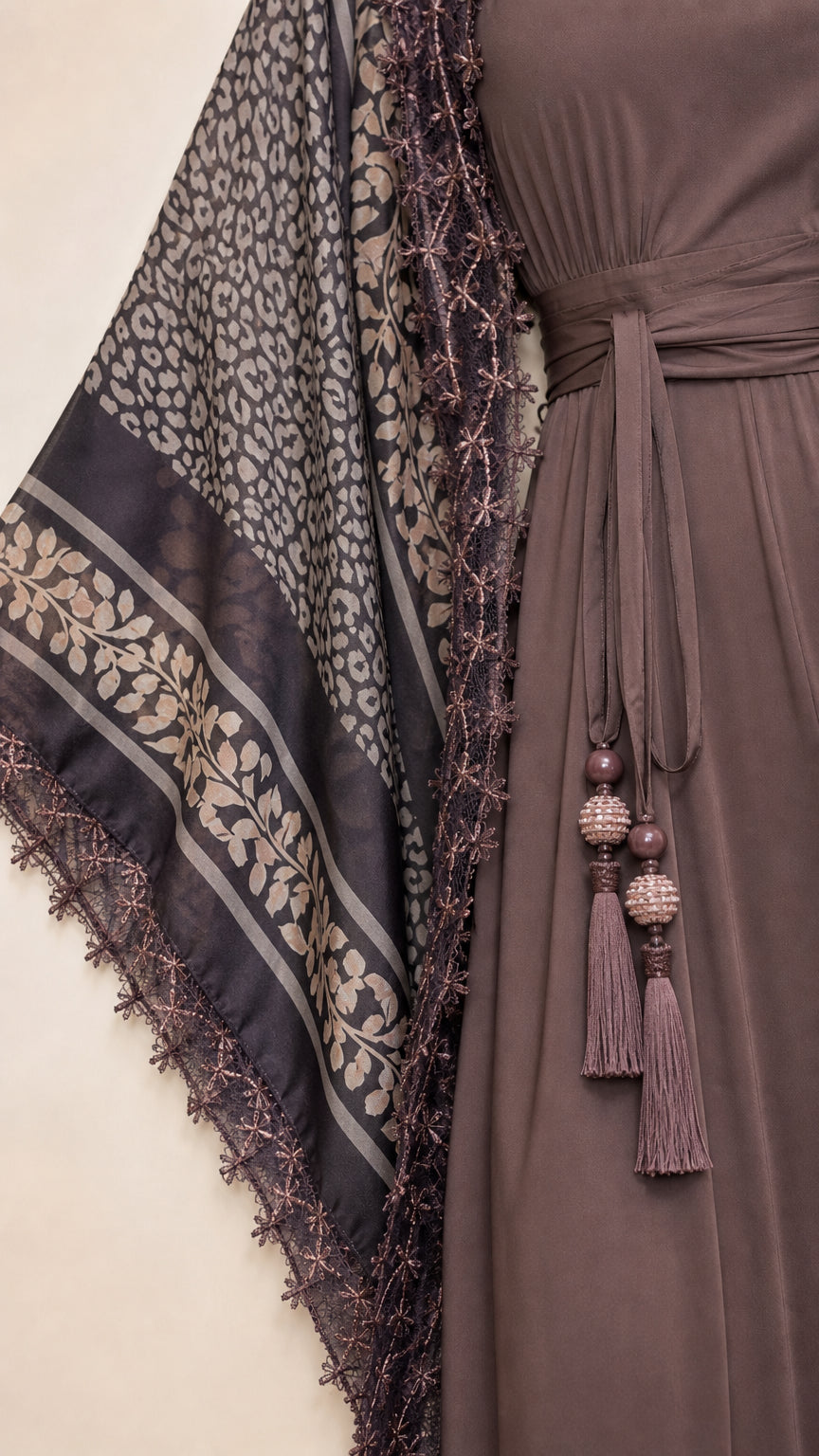 Close-up detail of sheer printed fabric, fringe trim, and beaded tassel belt