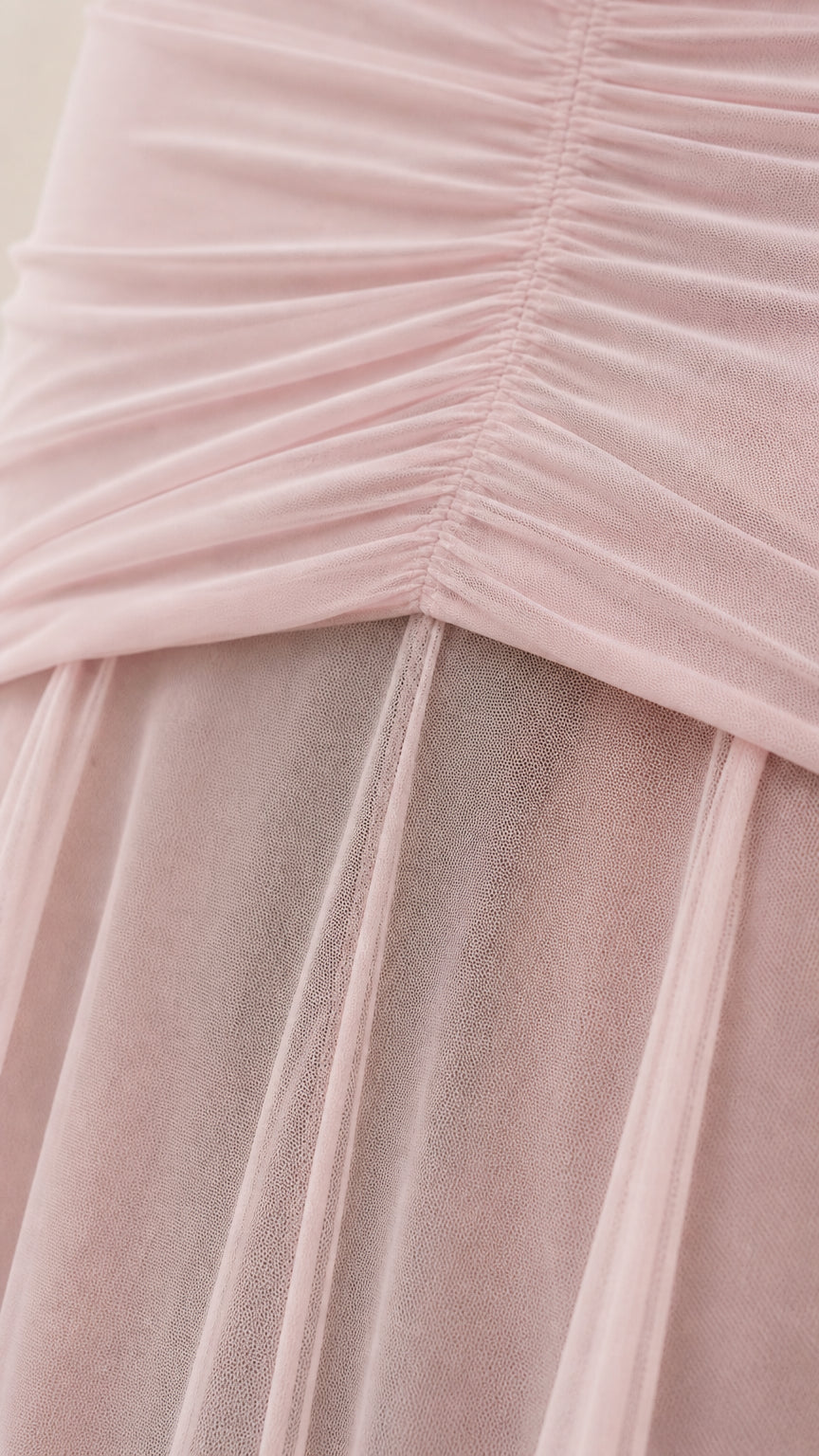 Close-up detail of bodice ruching and sheer mesh skirt layer
