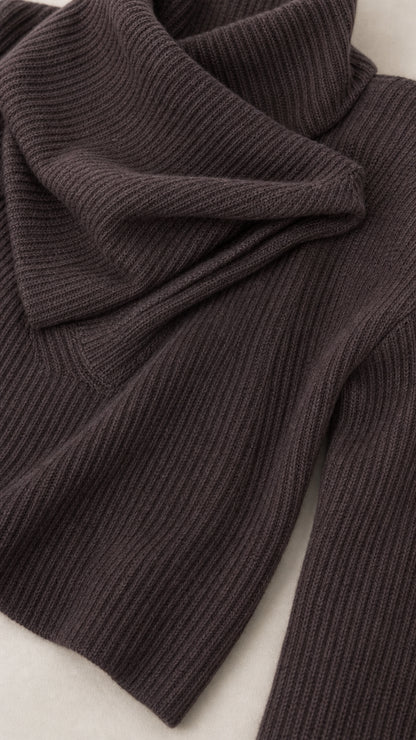 Close-up detail of dark brown ribbed knit fabric texture and asymmetrical neckline