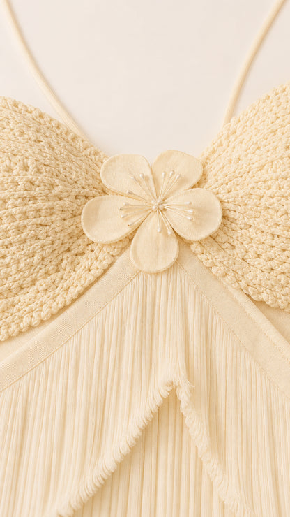Close-up detail of textured knit bodice with 3D floral accent and tiered fringe