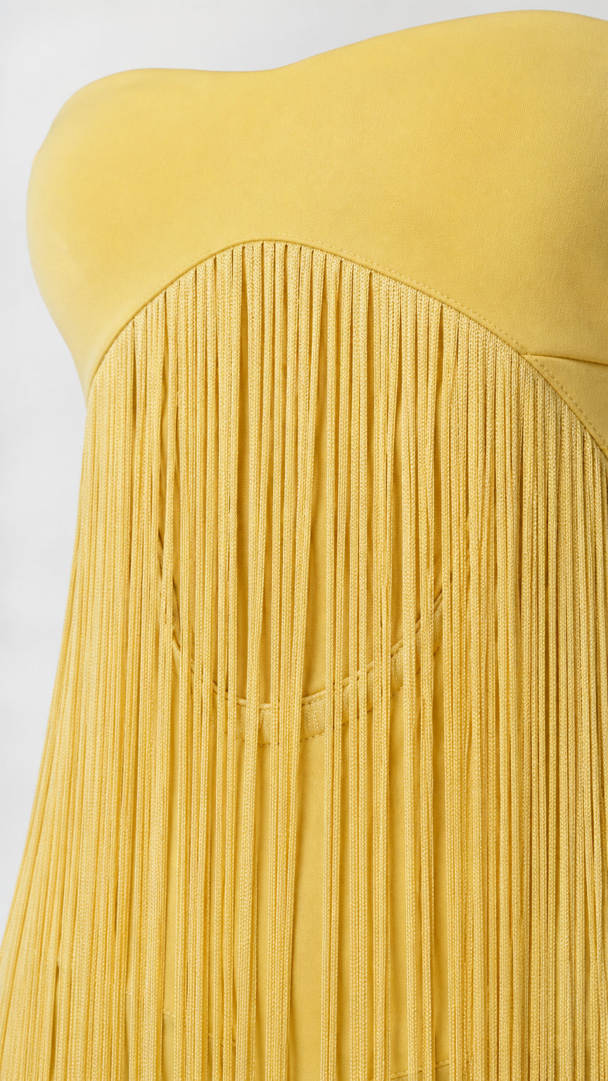 Close-up detail of yellow strapless bodice and fringe texture