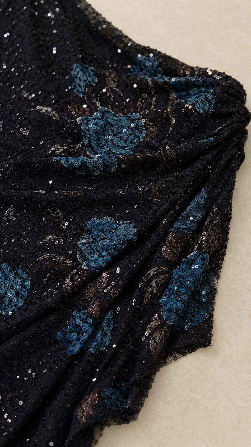 Close-up detail of black fabric with blue sequin floral embroidery