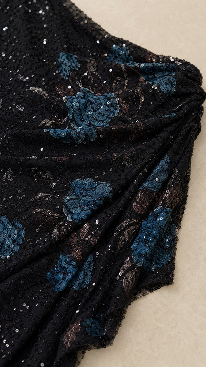 Close-up detail of black fabric with blue sequin floral embroidery