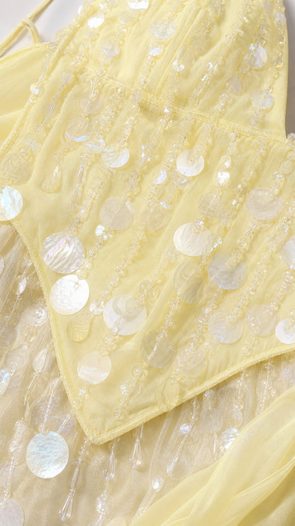 Close-up detail of sequins on yellow dress