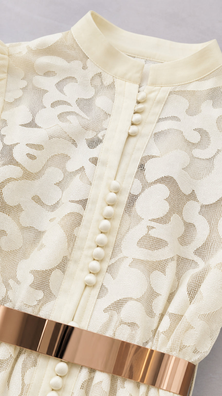 Close-up detail of mandarin collar and button placket on off-white dress