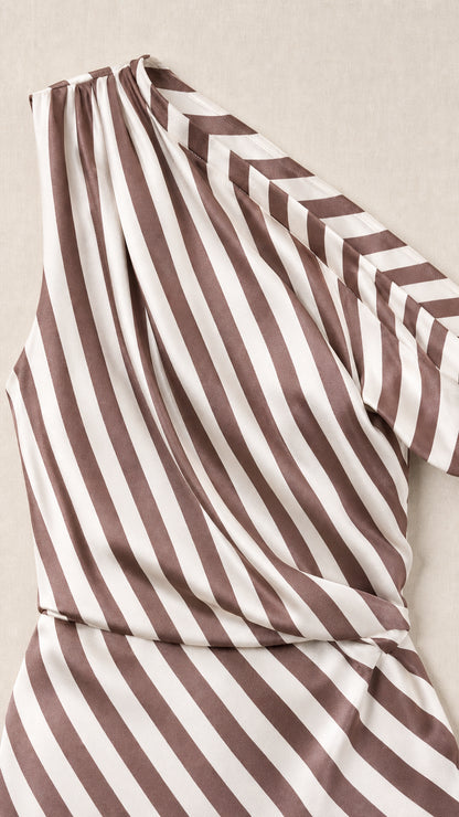 Close-up detail of fabric and one-shoulder strap of brown striped dress