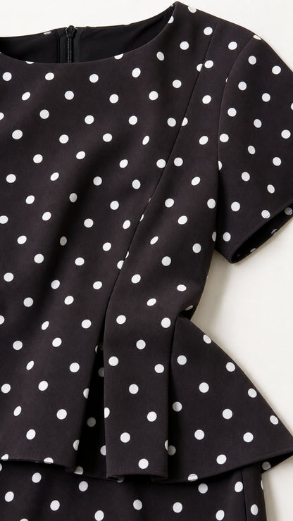 Close up detail of black polka dot fabric and peplum hem