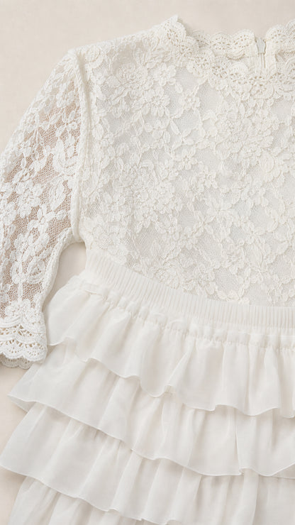 Close-up detail of white floral lace bodice and high mock neckline
