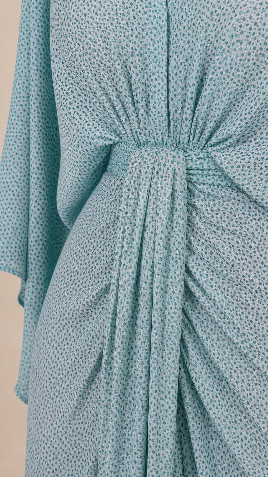 Close-up detail of front knot and gathered draping on light blue dress