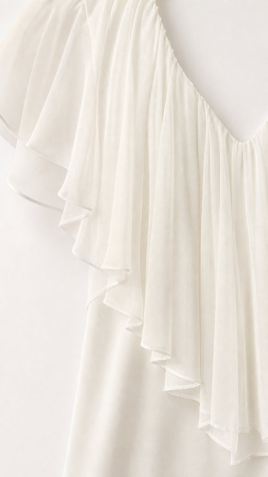 Close-up detail of sheer layered ruffle fabric on white crop top