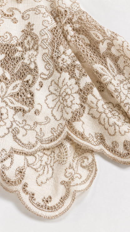 Close-up detail of Cream floral lace and scalloped sleeve hem