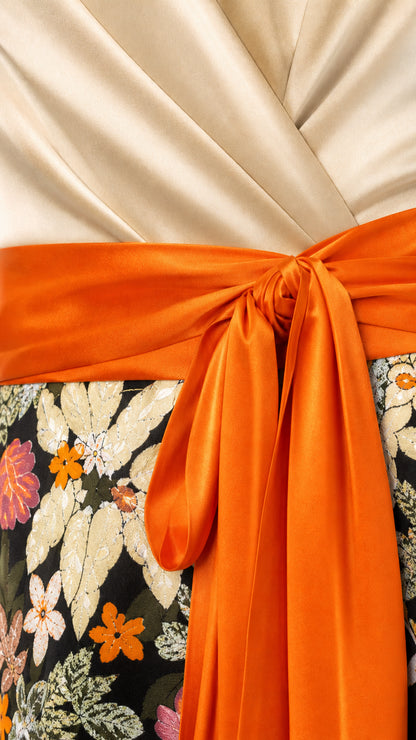 Close-up detail of satin wrap bodice and orange sash bow