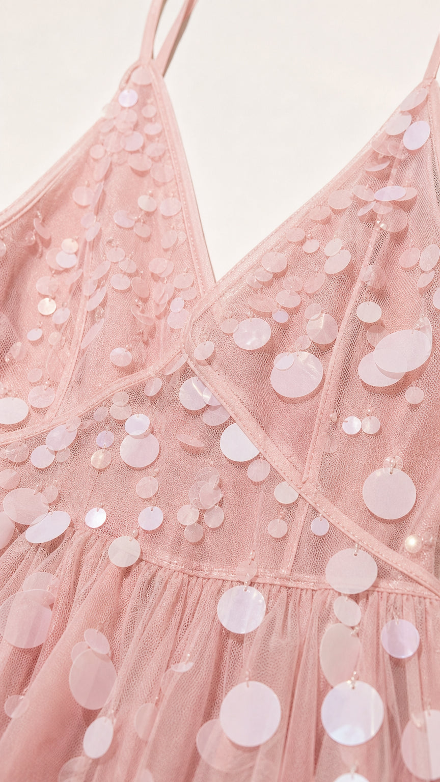 Close-up detail of V-neckline and sequin paillettes on pink dress