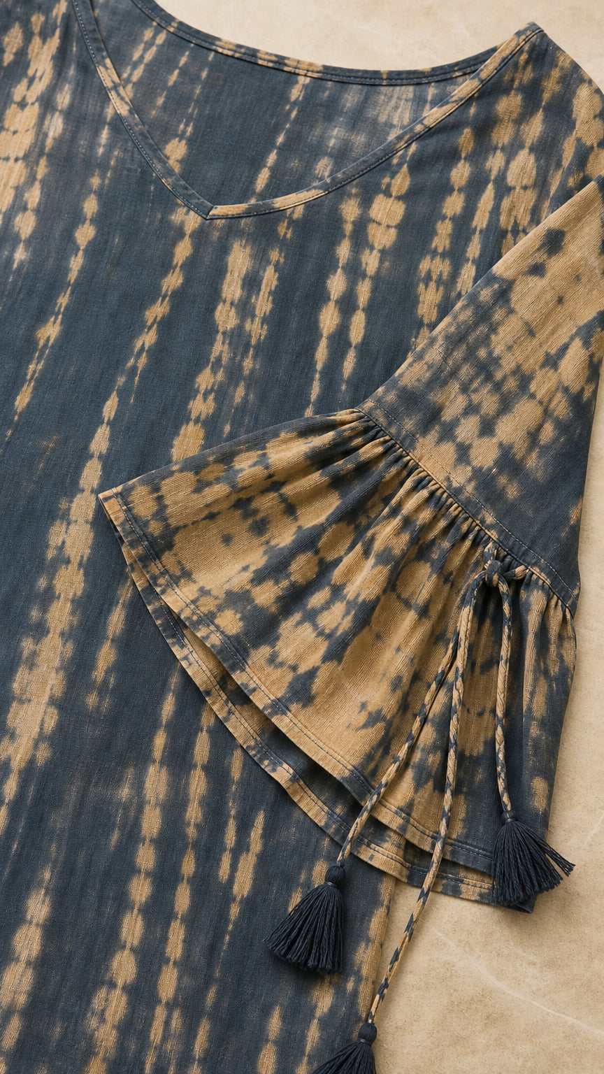 Close-up detail of V-neck, bell sleeve, and tassel ties
