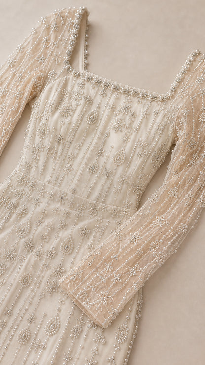 Close-up detail of intricate beadwork and embroidery on Champagne tulle fabric