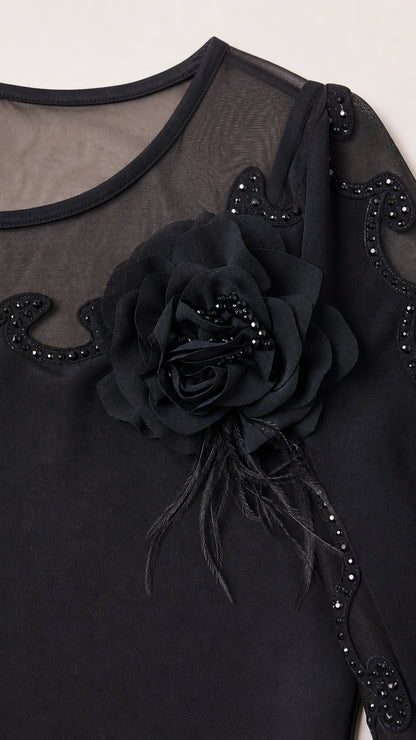 Close up of neckline showing sheer mesh, beaded floral applique and 3/4 sleeve