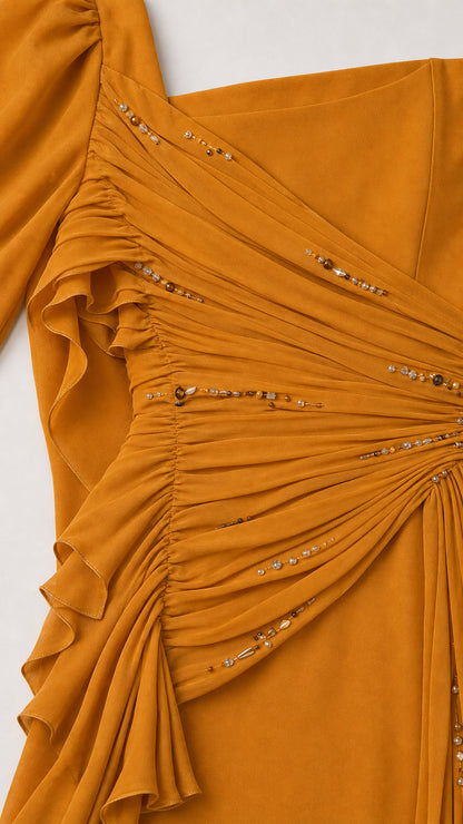 Close-up of ruched bodice and beaded accents on mustard gown