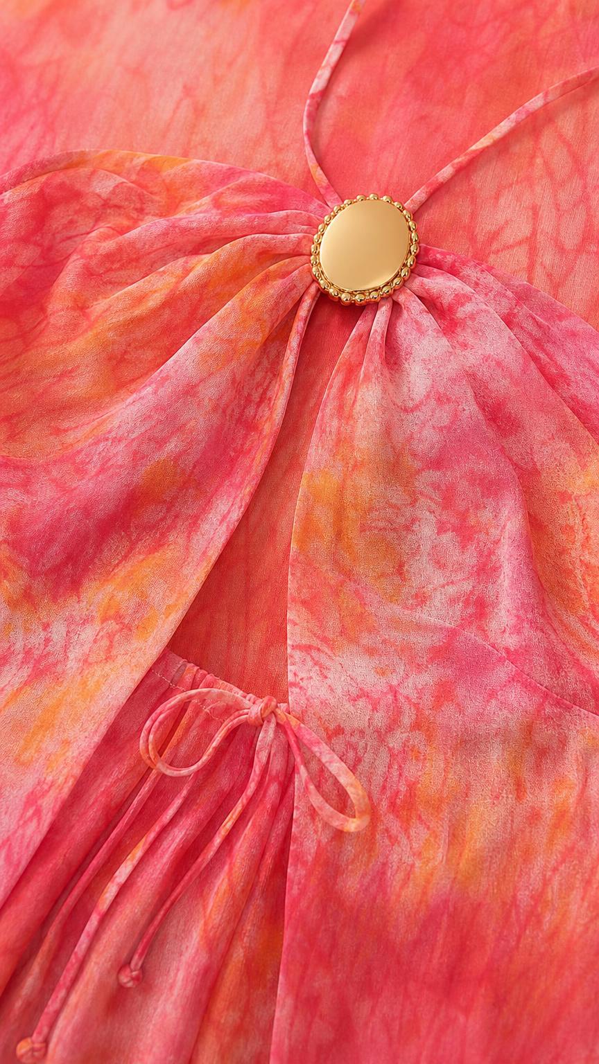 Close-up detail of the gold-tone metal hardware and cutout on the pink dress