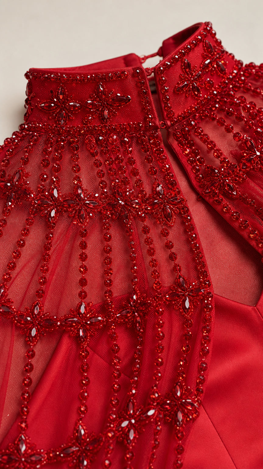 Close-up detail of red beaded mock neckline and mesh embroidery
