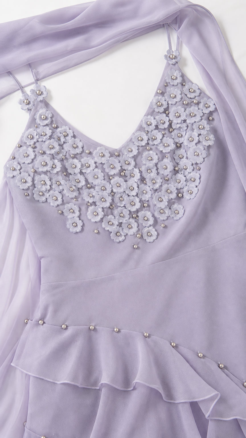 Close-up detail of 3D floral bodice applique and beaded ruffle hem