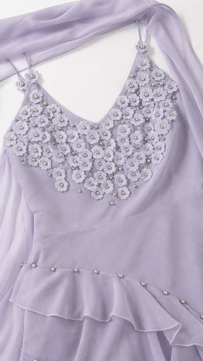 Close-up detail of 3D floral bodice applique and beaded ruffle hem