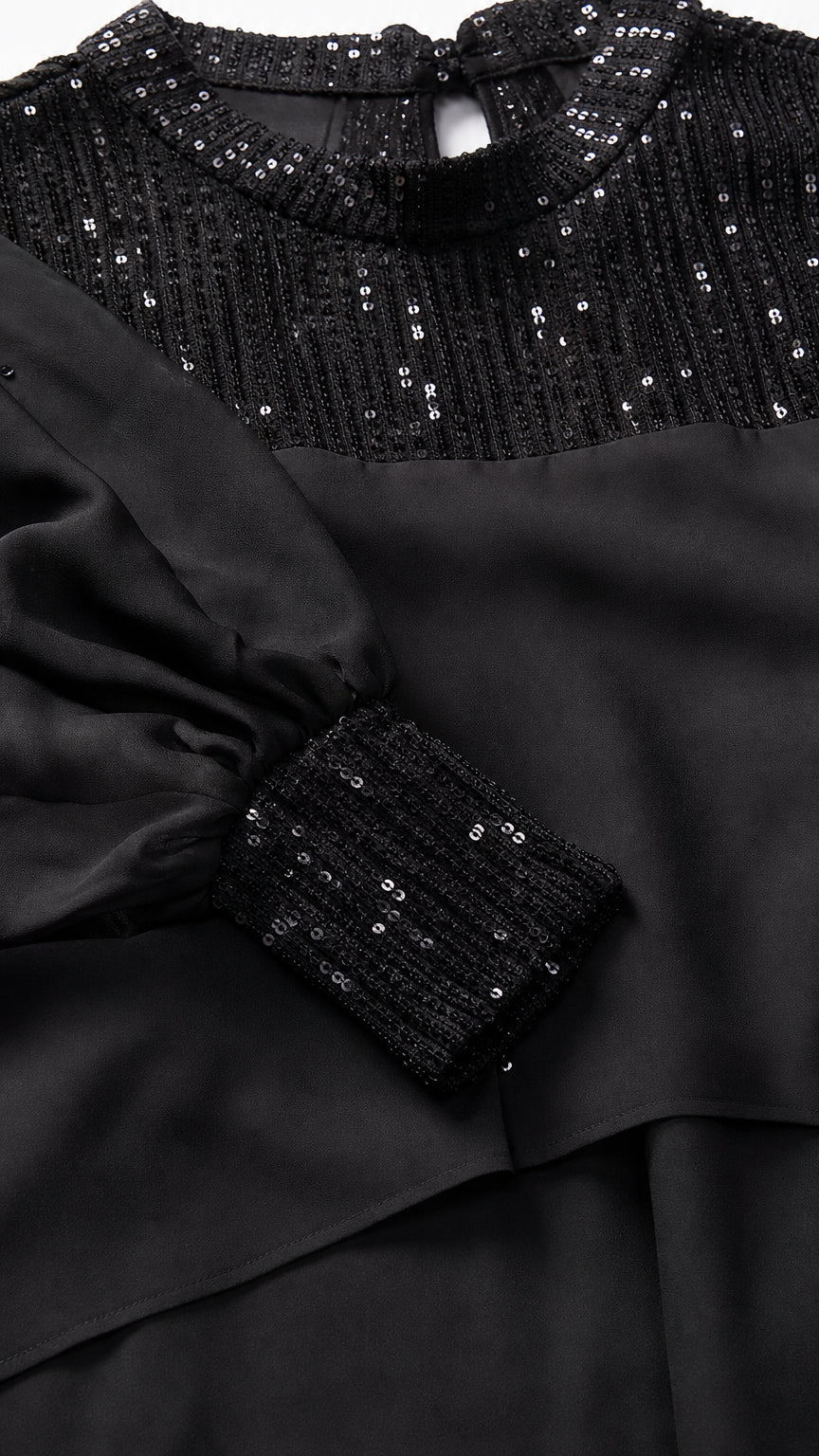 Close-up of black sequin mock neck and embellished cuffs
