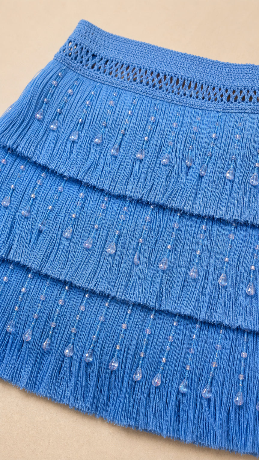 Close-up detail of blue fringe and beaded skirt texture