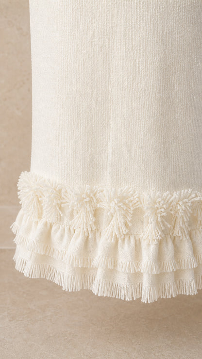 Close-up detail of the fringe hem on the white tweed maxi skirt