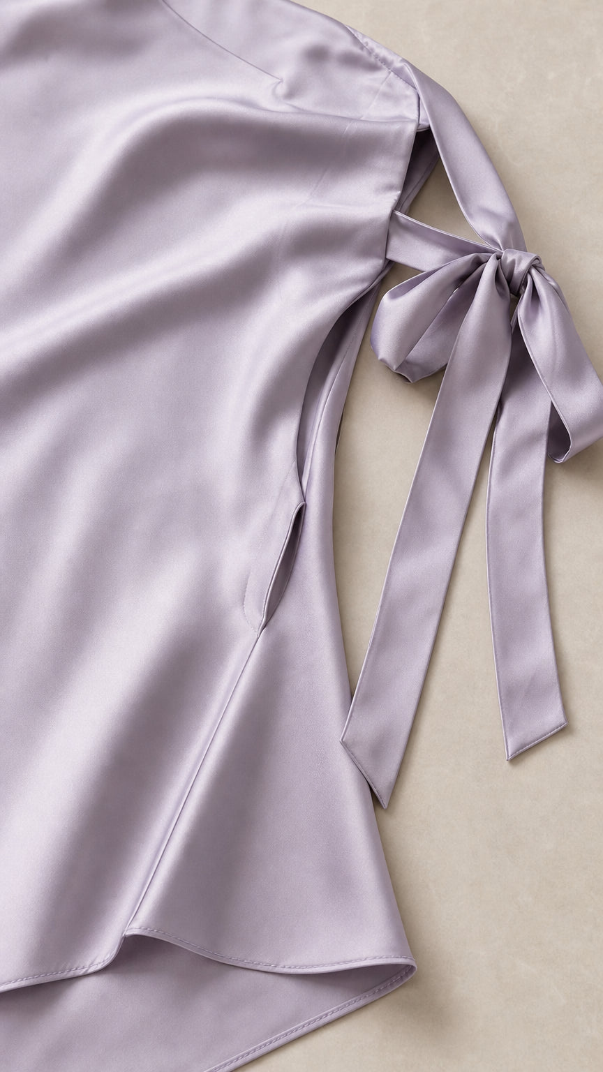 Close-up of fabric and shoulder tie detail on lavender satin dress