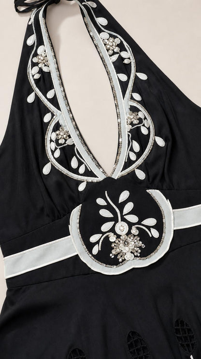 Close up of neckline and embroidery detail on black dress