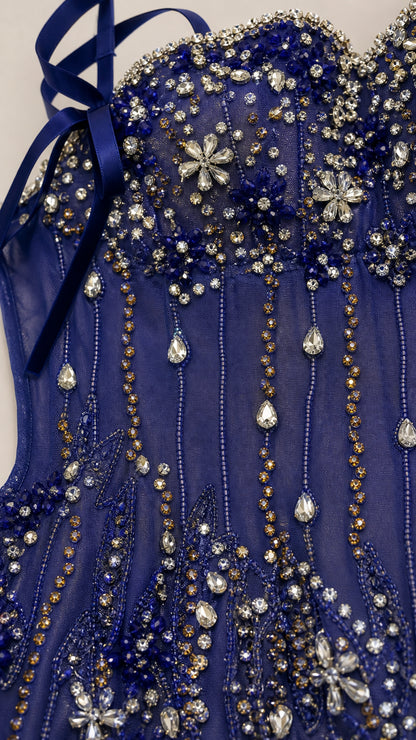 Close-up detail of crystal beadwork and floral appliqués on the bodice