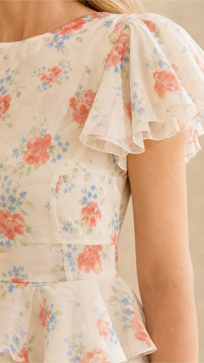 Close-up of ruffle sleeves and bodice on cream floral dress