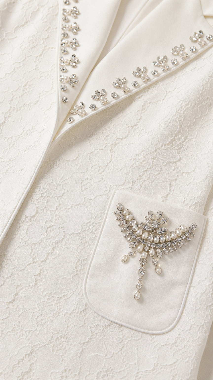 Close-up detail of rhinestone lapel trim and pearl-accented pocket brooch