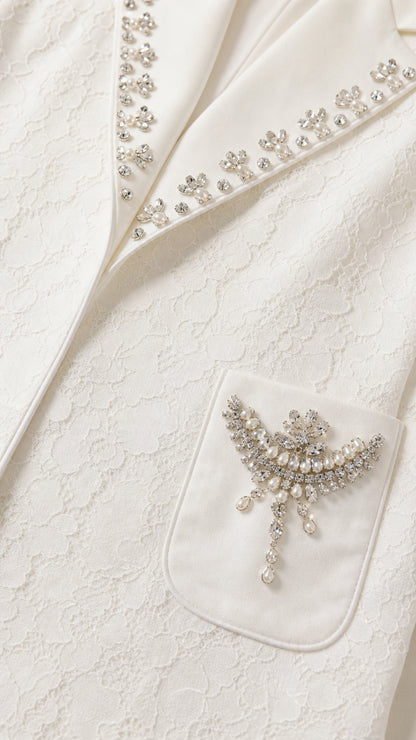Close-up detail of rhinestone lapel trim and pearl-accented pocket brooch