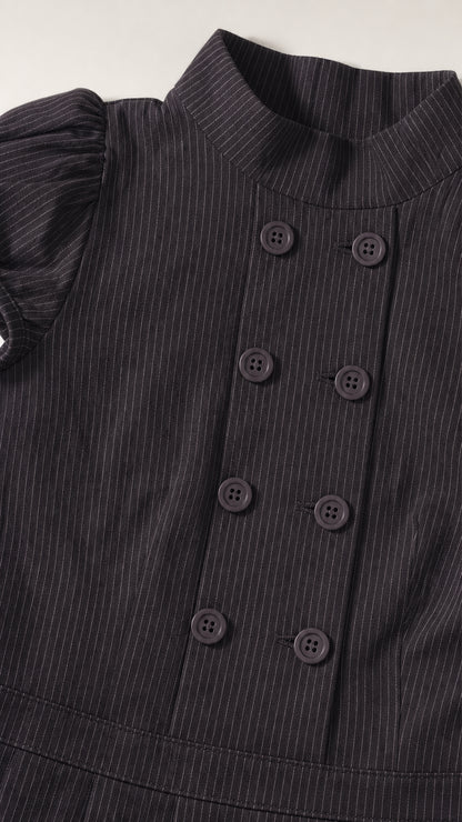 Close up of mock neck and double breasted buttons on black dress