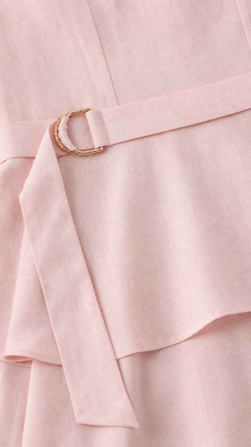 Close-up of the belt and peplum waist detail on the pink dress