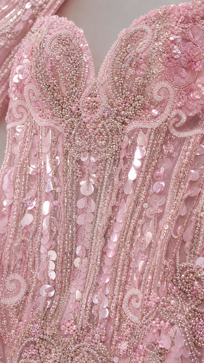 Close-up detail of intricate blush pink sequin, pearl, and beaded scrollwork embroidery