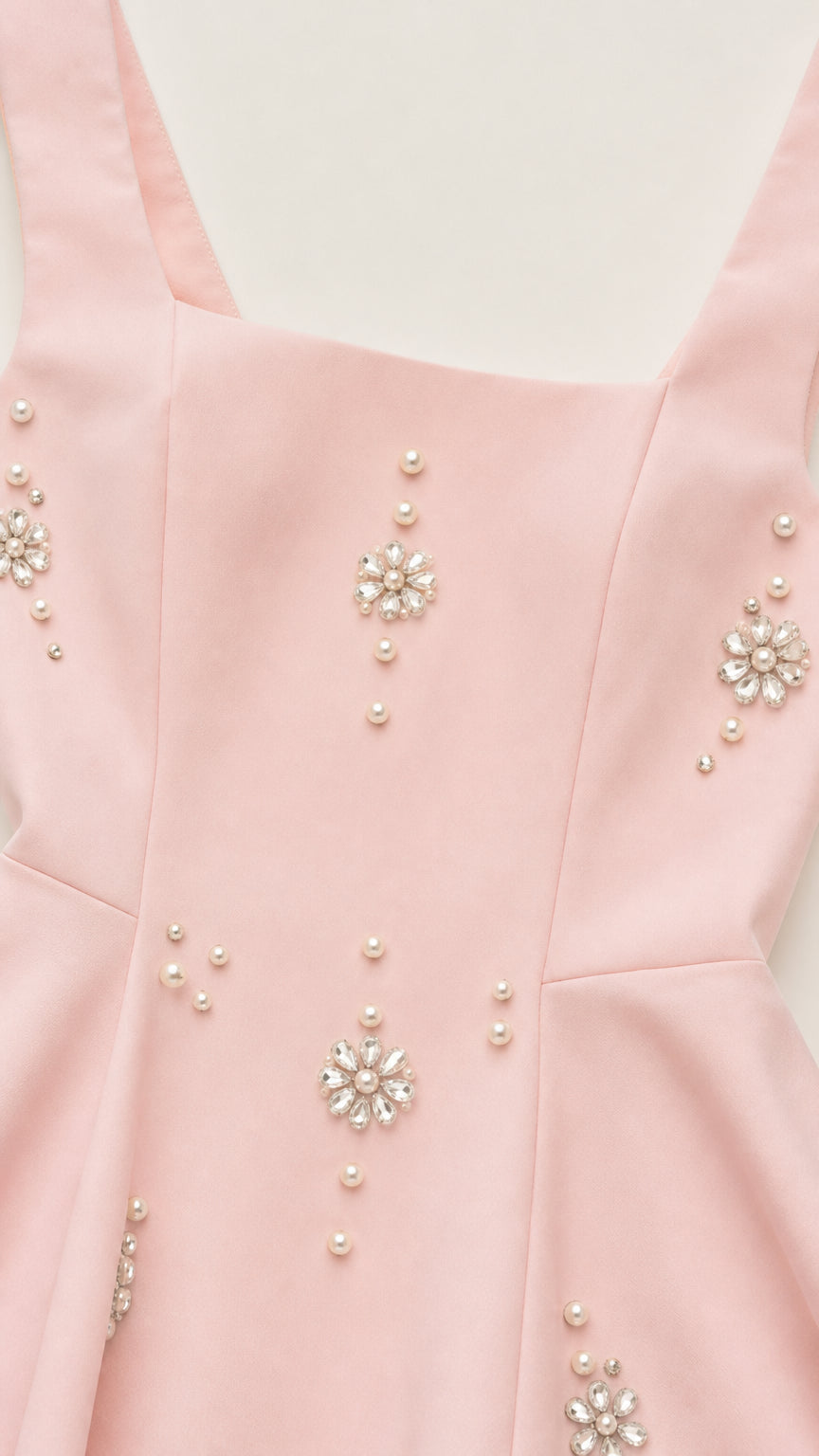 Close-up of crystal and pearl embellishments on pink dress