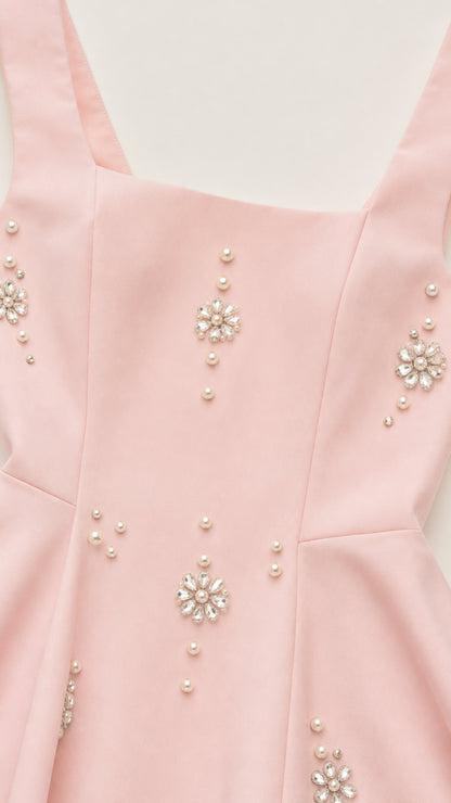 Close-up of crystal and pearl embellishments on pink dress