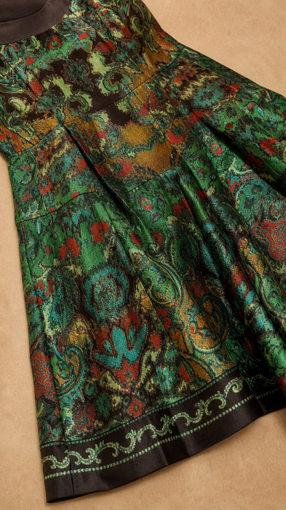 Close-up detail of green and bronze floral jacquard fabric and bordered hem