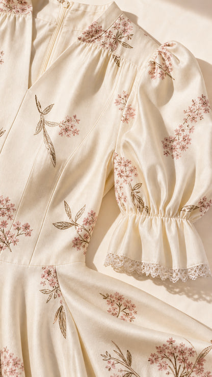 Close-up of bodice, embroidery, and lace cuff details on cream dress
