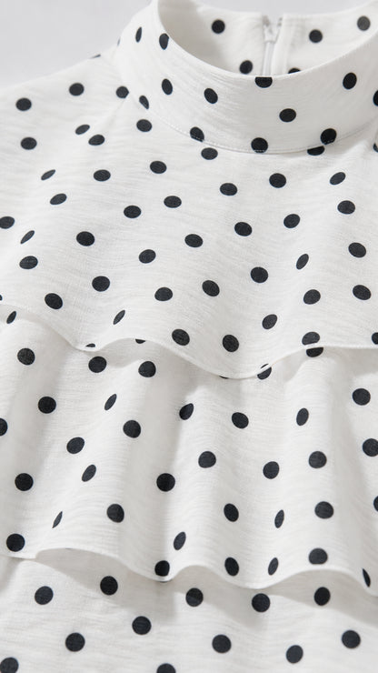 Close-up detail of high neckline and polka dot ruffle tiers