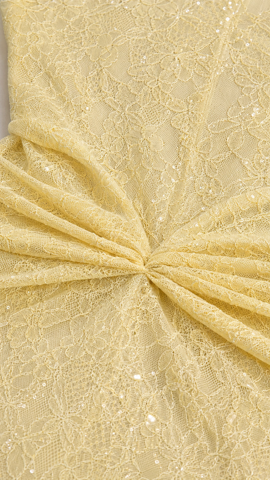 Close up view of floral lace fabric with subtle sequin details and gathered knot