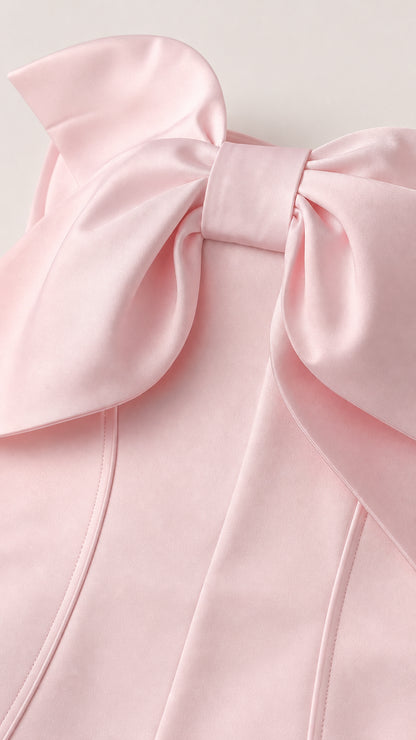 Close-up detail of the structured oversized bow on the pink corset bodice