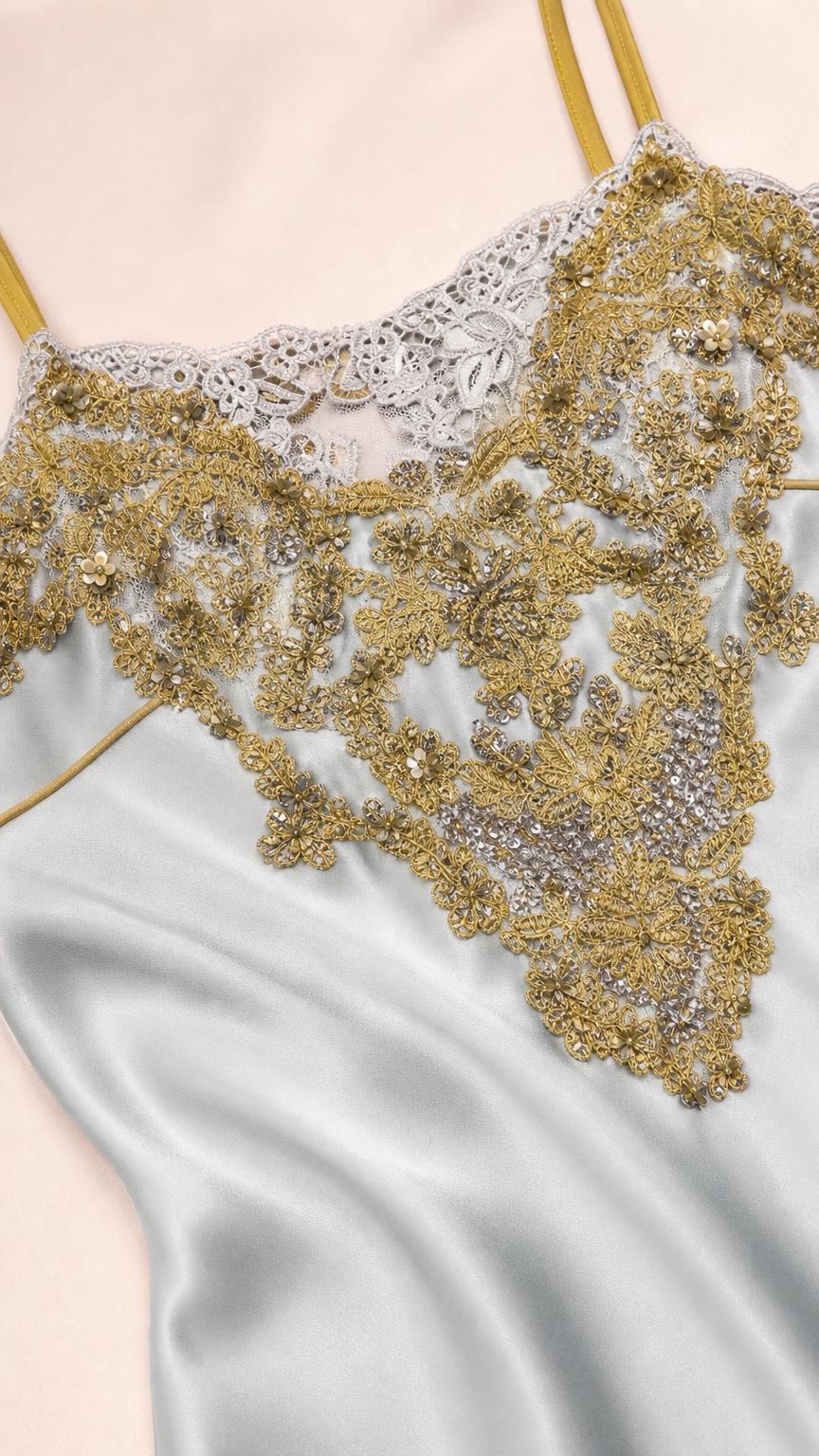 Close-up detail of lace and metallic gold embroidery on bodice