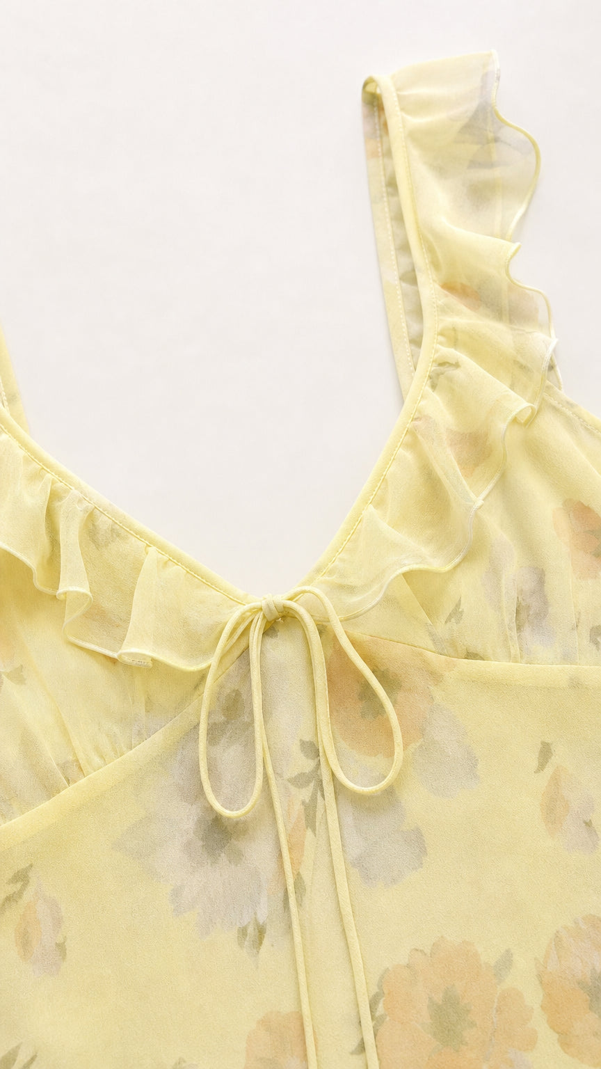 Close-up detail of tie-front neckline and ruffle straps in yellow