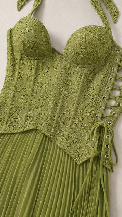 Close-up detail of green lace corset bodice with side lace-up grommets and pleated skirt