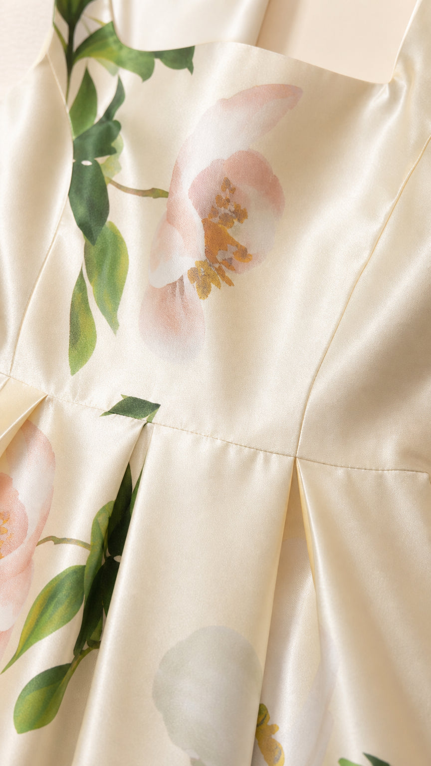 Close-up of the smooth ivory floral dress fabric and skirt seam
